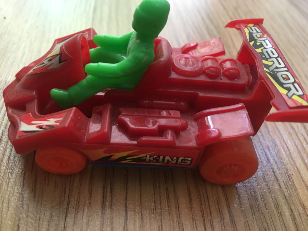 Zabawka czerwony wyscigowy samochodzik z ludzikiem bolid