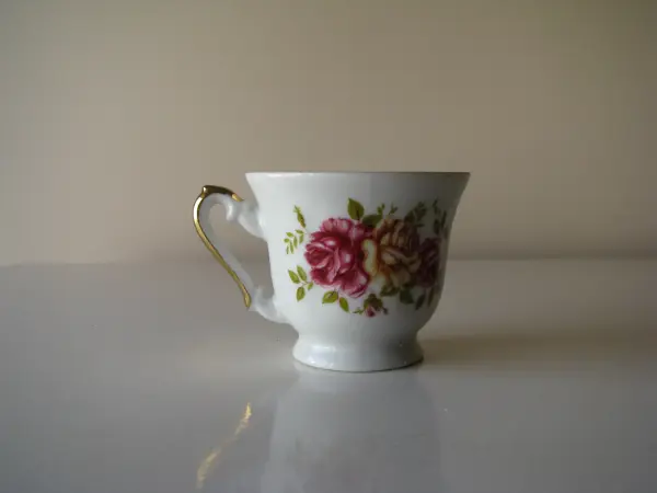 Stara, piękna, porcelanowa filiżanka ze złoceniami i motywem