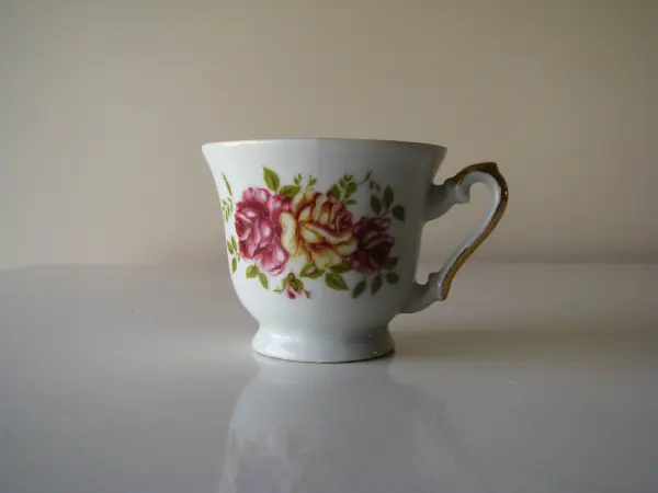 Stara, piękna, porcelanowa filiżanka ze złoceniami i motywem